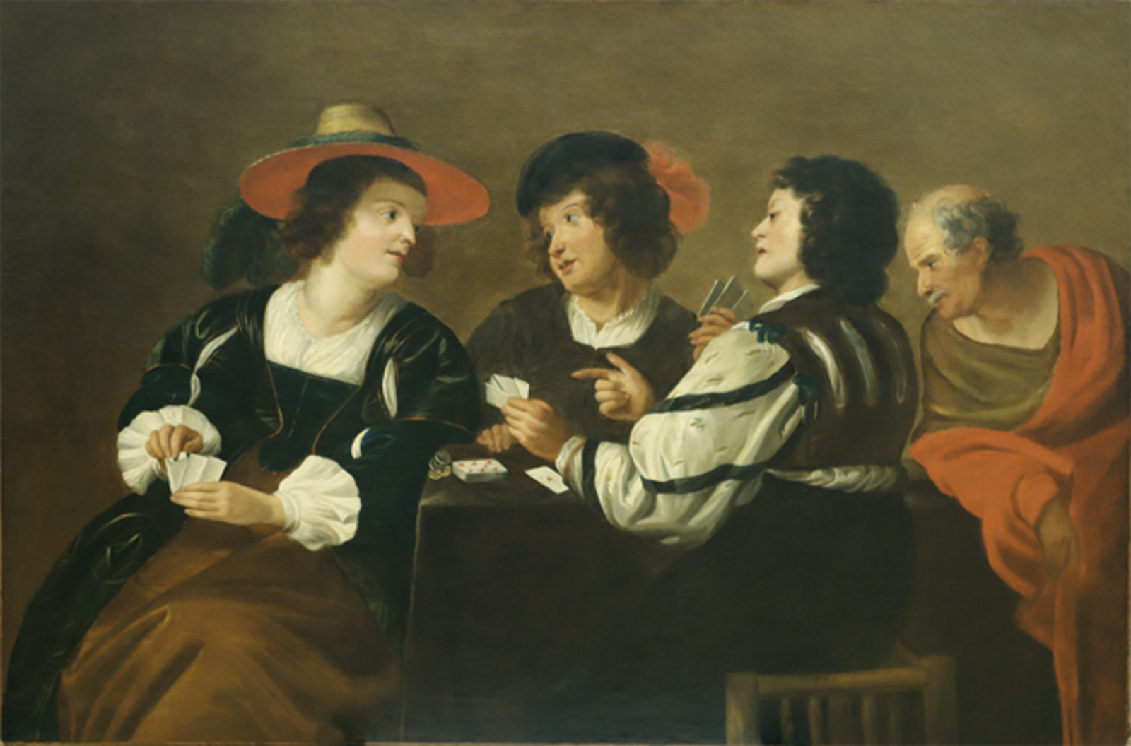 Drei Männer und eine Frau beim Kartenspiel an einem Tisch.
