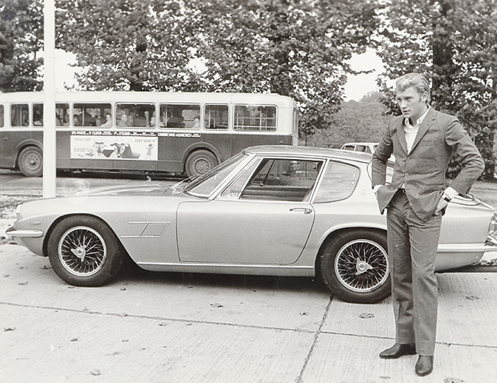 Der Sänger Johnny Halliday bei einem Jensen Interceptor Automobil (gen. Gold Fish Bowl) stehend.